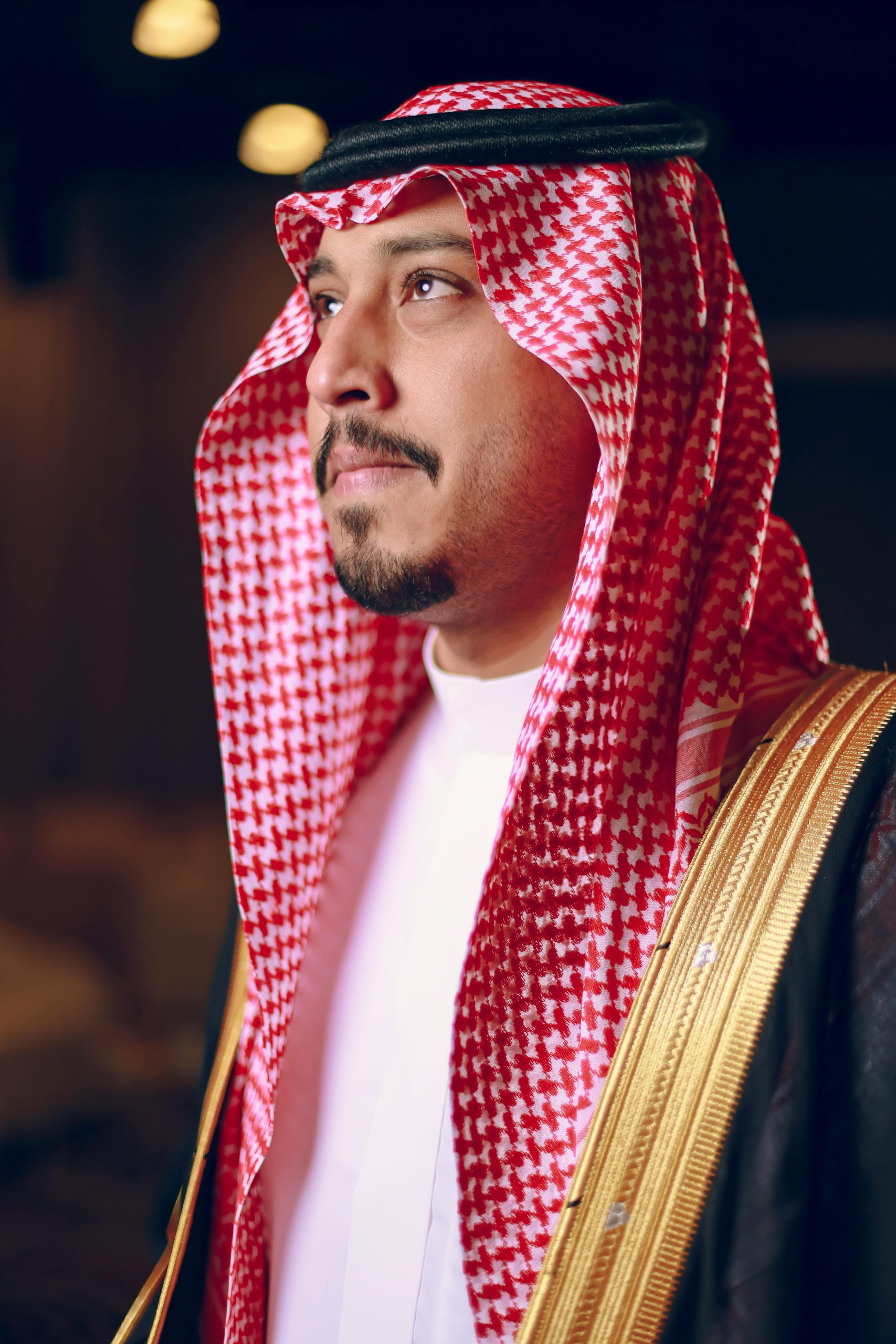 Portrait of a man in traditional Middle Eastern attire, indoors.